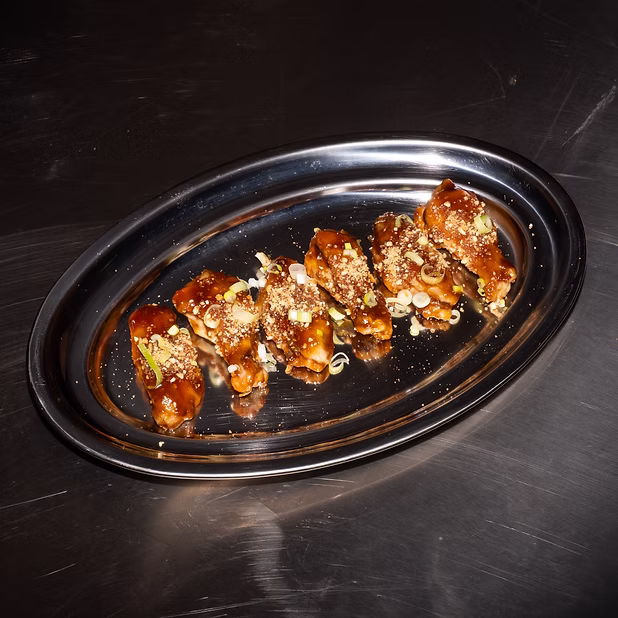 Alitas de Pollo - Bañadas en nuestra salsa coreana con crunch de kikos y cebolleta china.